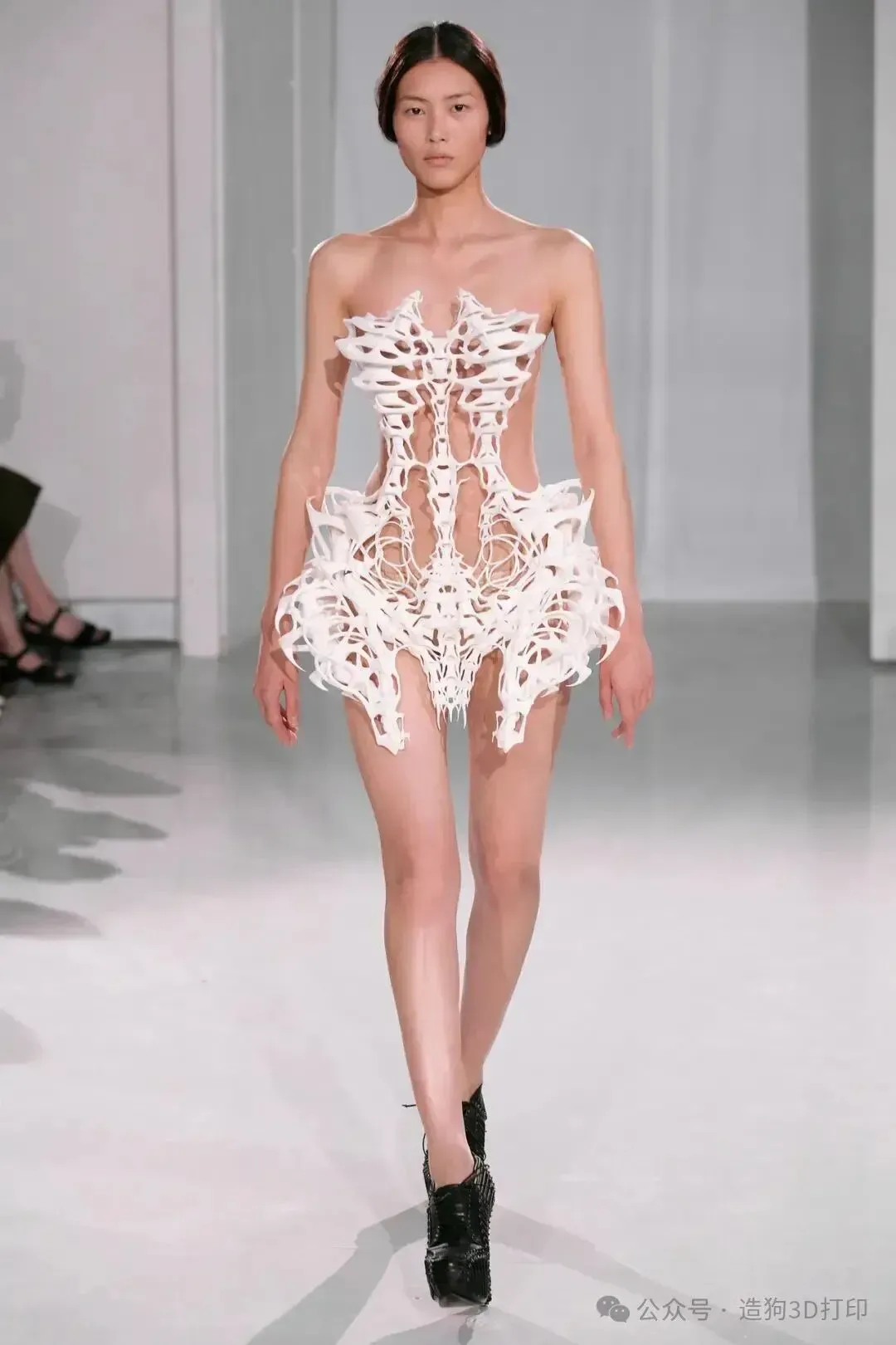 以Iris van Herpen 2011秋冬高定「白骨裙」为例，解析SLS激光烧结尼龙粉末如何以高精度和层积肌理塑造外骨骼时装，并延伸至复合材料馆藏保存难题。