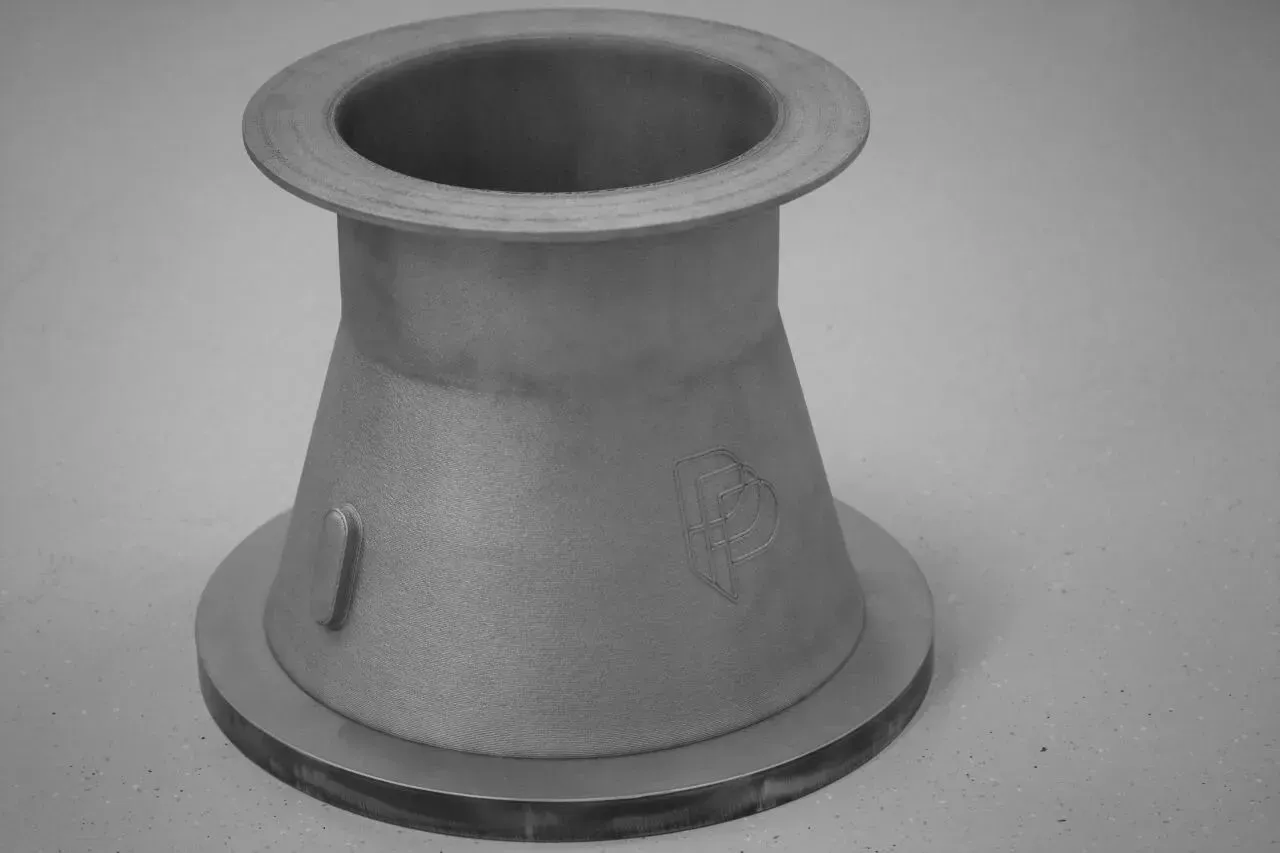 CETIM在Printing Bourges平台用AddUp五轴DED与NX编程链打印316L大喷嘴，单件切换薄壁、涂层、堆积、旋转策略，优化空行程与防碰撞，验证高件稳健性并展示开放协同供应链模式。