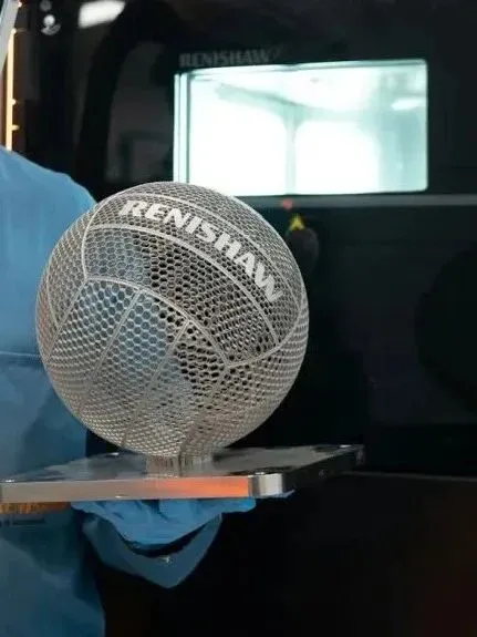 雷尼绍借世界杯发布钛合金3D打印5号足球，采用隐式建模与动态激光参数实现复杂曲面无支撑成型，重约210克，意在验证工艺极限并展示轻量化曲面制造能力。
